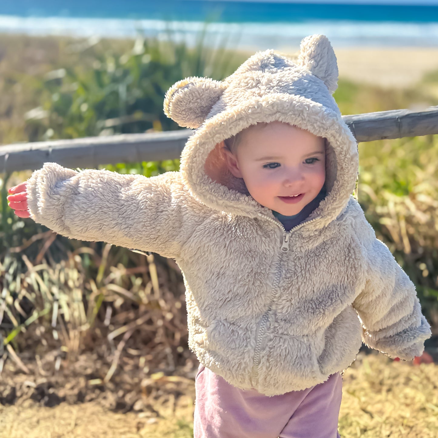 Coco wears the fluffy Cub Jacket in Cream at the beach